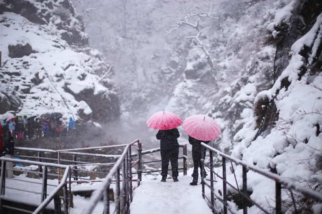 Two people strolling through a snowy Nozawa Onsen